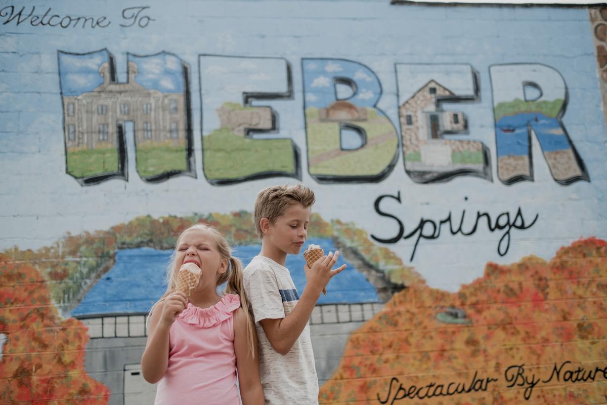 Kids eating ice cream cones in front of mural downtown