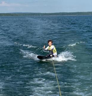Child knee boarding on the lake